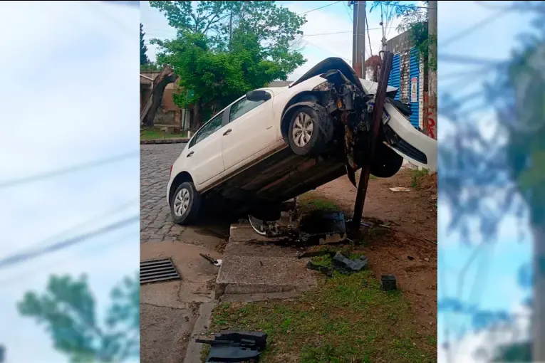 Joven conductora despistó y terminó con su auto “montado” sobre una estructura metálica